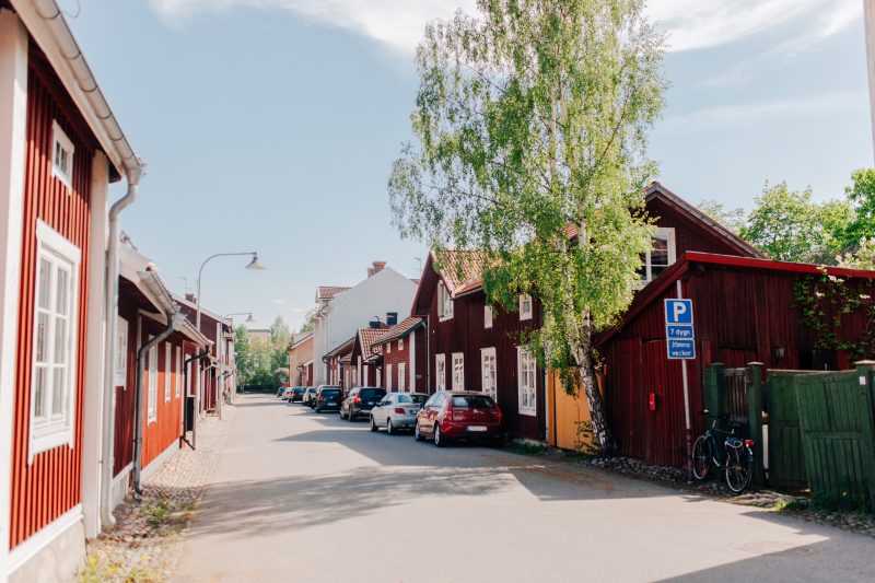 Parkerade bilar längs med lummig gågata i centrala Falun
