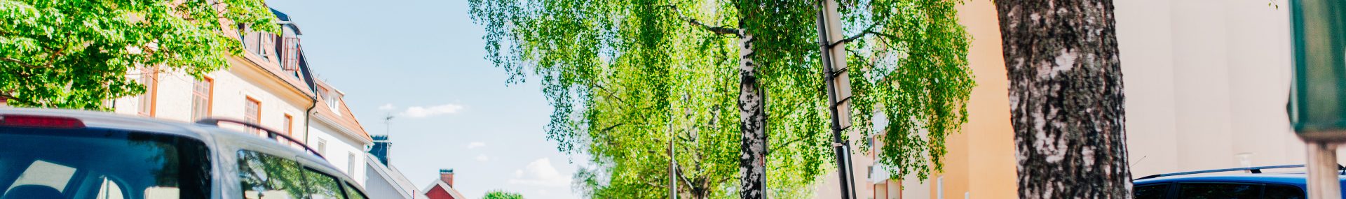 Parkerade bilar på var sida i ett grönskande Falun